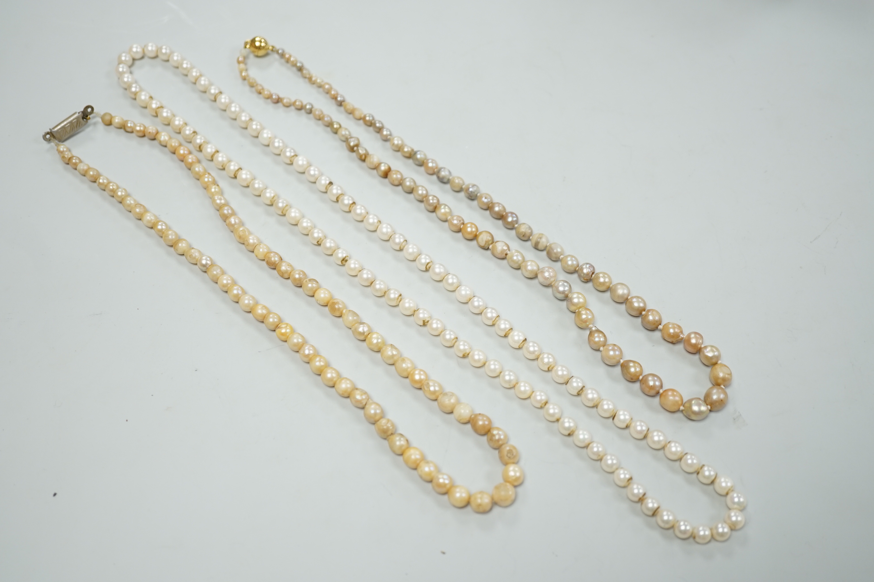 Three assorted single strand cultured pearl necklaces, longest 58cm.
